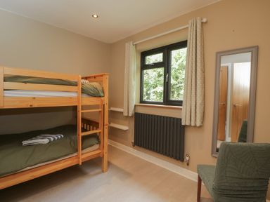 A bedroom with a bunk bed and a window at Willow Cottage in Whiteparish