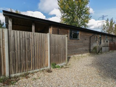 A wooden fenced area with a gravel driveway at Willow Cottage Whiteparish