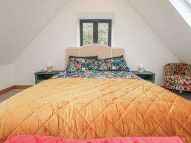 A bedroom with a bed and armchair at Barn 2