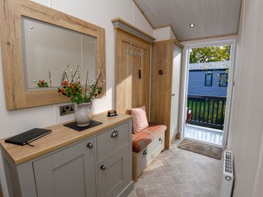 A entrance hall with a mirror and cabinets at Lakewood Retreat in Woodhall Spa