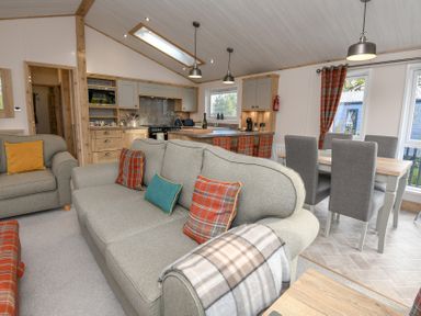 A living room with a sofa and dining area at Lakewood Retreat in Woodhall Spa