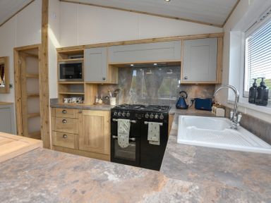 A kitchen with stove and sink at Lakewood Retreat in Woodhall Spa