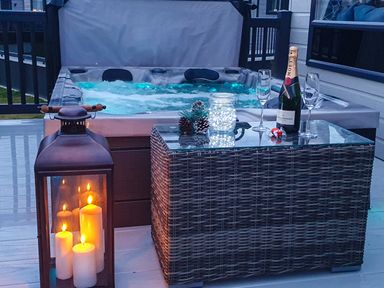 An outdoor area with a hot tub and drinks at Hotchkin Lodge in Woodhall Spa