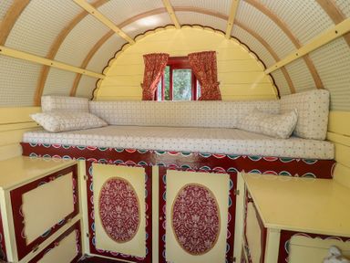 A sleeping area with a bed and cabinets at The Bowtop Gypsy Caravan in Eye