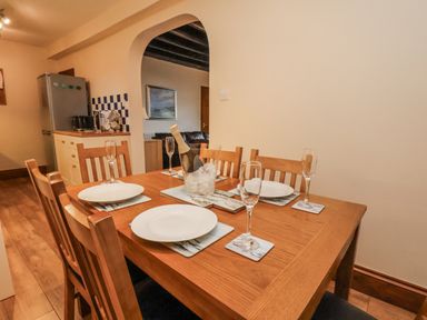 A dining room with a table set for a meal at 2 High Stakesby Cottages in Whitby