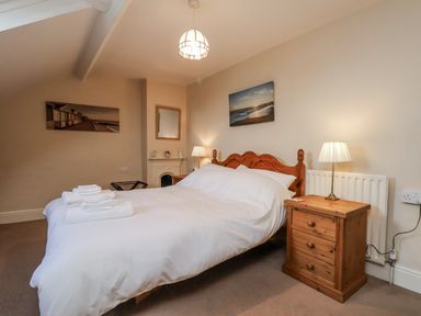 A bedroom with a bed and nightstand at 2 High Stakesby Cottages in Whitby
