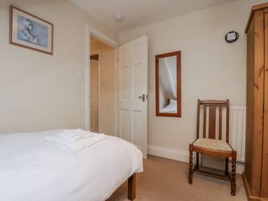 A bedroom with a bed and a chair at 2 High Stakesby Cottages in Whitby