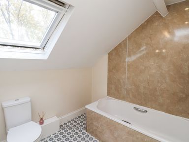 A bathroom with a bathtub and toilet at 2 High Stakesby Cottages in Whitby