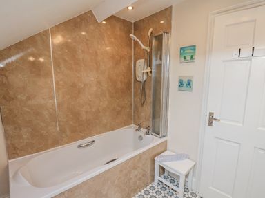 A bathroom with a bathtub and shower at 2 High Stakesby Cottages in Whitby