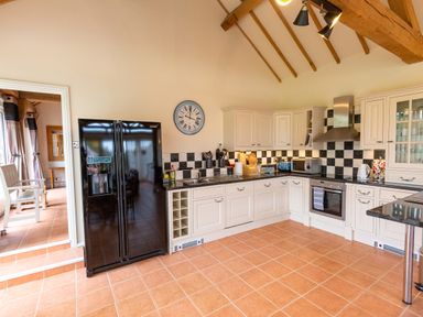 A kitchen with refrigerator, sink, and oven at Nature's Lodge in Cookley