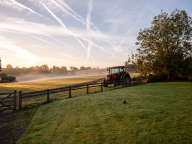 A tractor near a fence on a grassy field at Nature's Lodge in Cookley