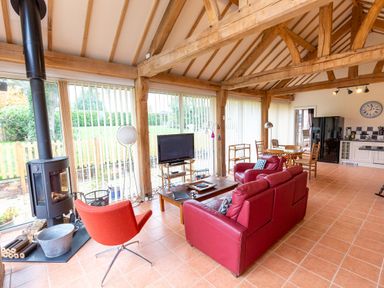 A living room with a sofa, coffee table, and television at Nature's Lodge in Cookley