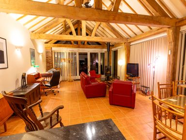 A living room with a sofa, chairs, and a fireplace at Nature's Lodge in Cookley