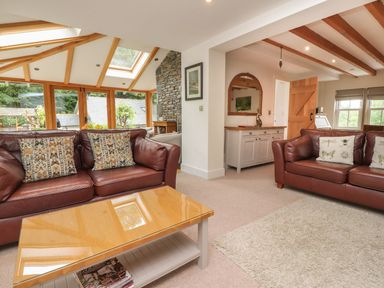 A living room with sofas and a coffee table at Bobbin Mill Cottage in Ulverston