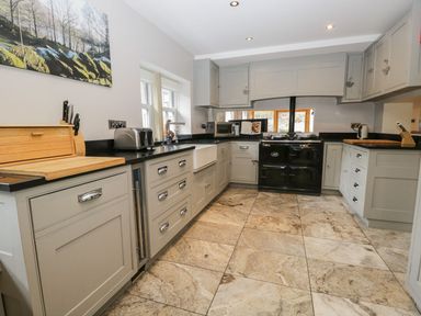 A kitchen with cabinets and stove at Bobbin Mill Cottage in Ulverston