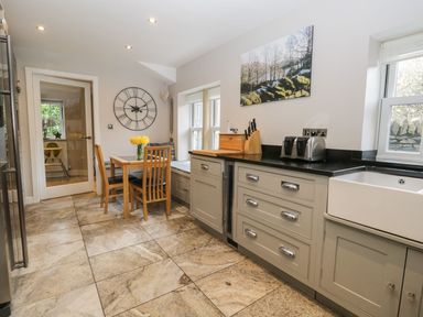 A kitchen with a dining table and chairs at Bobbin Mill Cottage in Ulverston