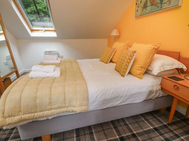 A bedroom with a bed and pillows at Bobbin Mill Cottage in Ulverston