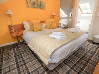 A bedroom with a bed and bedside table at Bobbin Mill Cottage in Ulverston