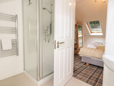A bathroom with a shower and bed area at Bobbin Mill Cottage in Ulverston