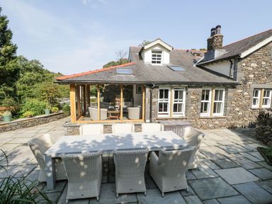 An outdoor seating area with a table and chairs at Bobbin Mill Cottage in Ulverston