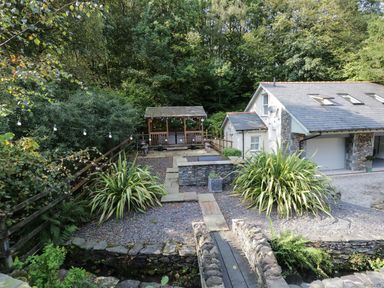 An outdoor area with a gazebo and stone pathway at Bobbin Mill Cottage in Ulverston