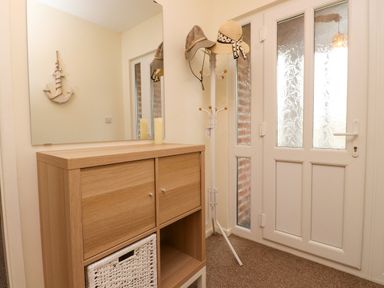 A hallway with a mirror and a hat rack at Gelli - Morfa Nefyn