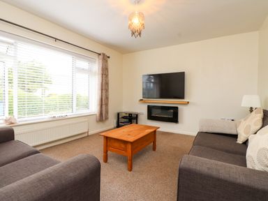 A living room with sofas and a television at Gelli - Morfa Nefyn in Morfa Nefyn