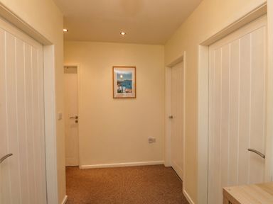 A hallway with doors and a picture frame at Gelli - Morfa Nefyn in Morfa Nefyn