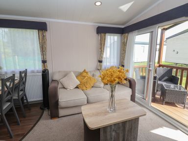 A living room with a sofa and a table at Stag Lodge, Caravan 70 Great Yarmouth