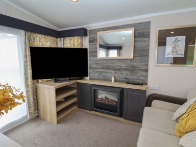 A living room with a television and fireplace at Stag Lodge, Caravan 70, Great Yarmouth