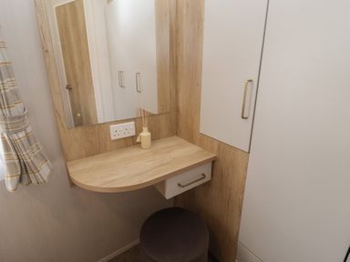 A dressing area with a mirror and shelf at Stag Lodge, Caravan 70 in Great Yarmouth