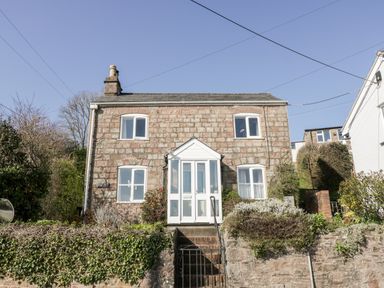 A stone house with four windows and a white porch at Gordons View Pleasant Stile near Gloucester
