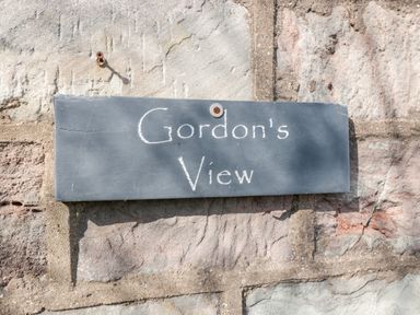 A rectangular stone sign with Gordons View written on it attached to a stone wall at Gordons View Pleasant Stile near Gloucester