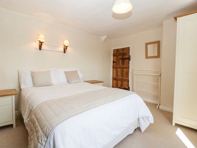 A bedroom with a double bed nightstands a wooden door a mirror and a wardrobe at Gordons View Pleasant Stile near Gloucester