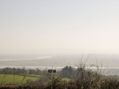 A rural landscape with fields trees and a public footpath sign at Gordons View Pleasant Stile near Gloucester