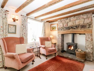 A sitting room with two armchairs a stone fireplace and wooden beams at Gordons View in Pleasant Stile near Gloucester