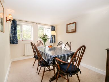 A dining room with a table covered by a checkered tablecloth and six chairs at Gordon's View Pleasant Stile near Gloucester