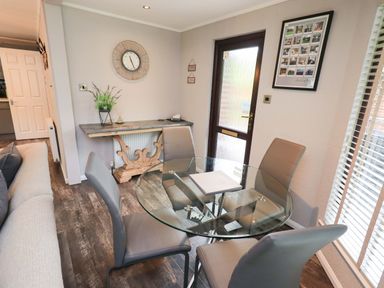 A dining room with a glass table and chairs at Costapacket Grasmere 12, White Cross Bay near Windermere