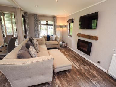 A living room with a sofa and television at Costapacket Grasmere 12, White Cross Bay near Windermere