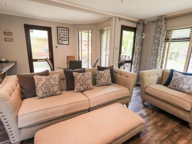 A living room with a sofa and armchairs at Costapacket, Grasmere 12, White Cross Bay near Windermere