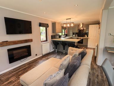 A living room with a kitchen area and seating at Costapacket Grasmere 12, White Cross Bay near Windermere