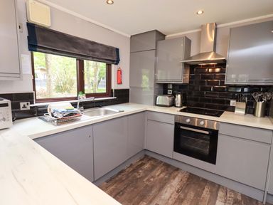 A kitchen with gray cabinets and appliances at Costapacket, Grasmere 12, White Cross Bay near Windermere