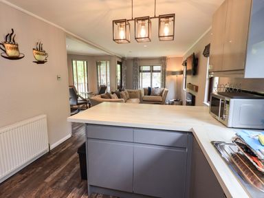 A kitchen with a dining table and sofa at Costapacket, Grasmere 12, White Cross Bay near Windermere