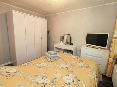 A bedroom with a bed, wardrobe, and television at Costapacket in Grasmere 12, White Cross Bay near Windermere