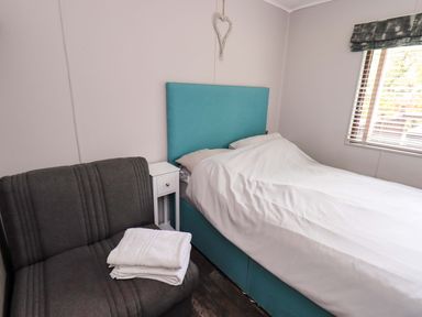 A bedroom with a bed and a sofa at Costapacket Grasmere 12, White Cross Bay near Windermere