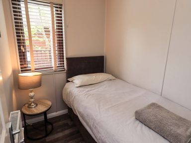 A bedroom with a bed and side table at Costapacket Grasmere 12, White Cross Bay near Windermere