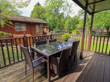An outdoor dining area with a table and chairs at Costapacket Grasmere 12, White Cross Bay near Windermere
