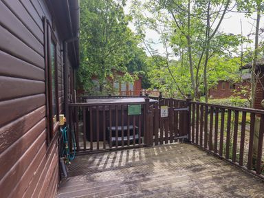 An outdoor area with a hot tub and wooden decking at Costapacket, Grasmere 12, White Cross Bay near Windermere