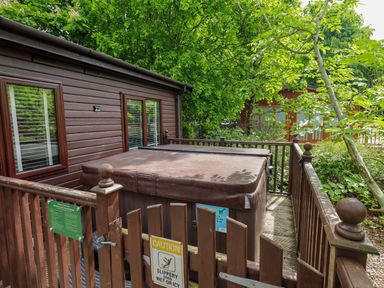 An outdoor area with a hot tub and wooden deck at Costapacket in Grasmere 12, White Cross Bay near Windermere