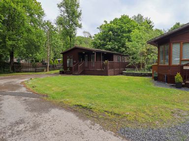 A cabin with a wooden deck in an outdoor area at Costapacket Grasmere 12, White Cross Bay near Windermere